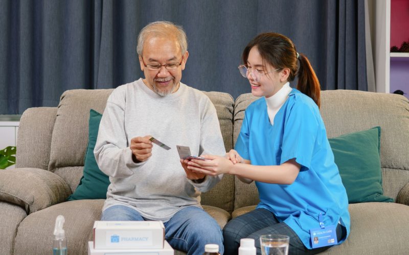 Caregiver nurse taking care of elderly grandfather at home